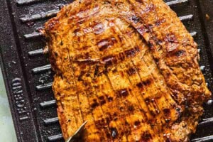 pineapple marinated flank steak on a grill.