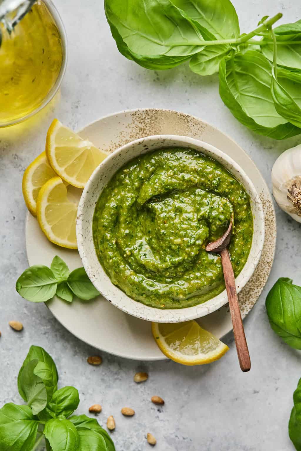 a bowl of vegan pesto on a plate with a wooden spoon.