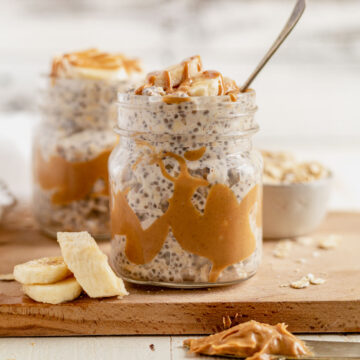 peanut butter overnight oats in a jar topped with sliced bananas and a spoon