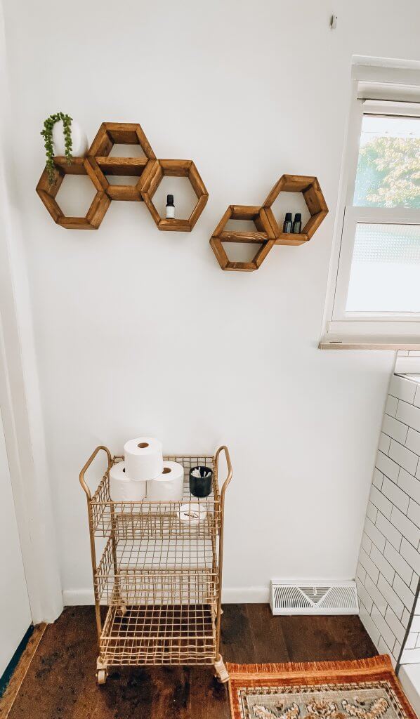 gold bar cart in the bathroom with hexagon shelving