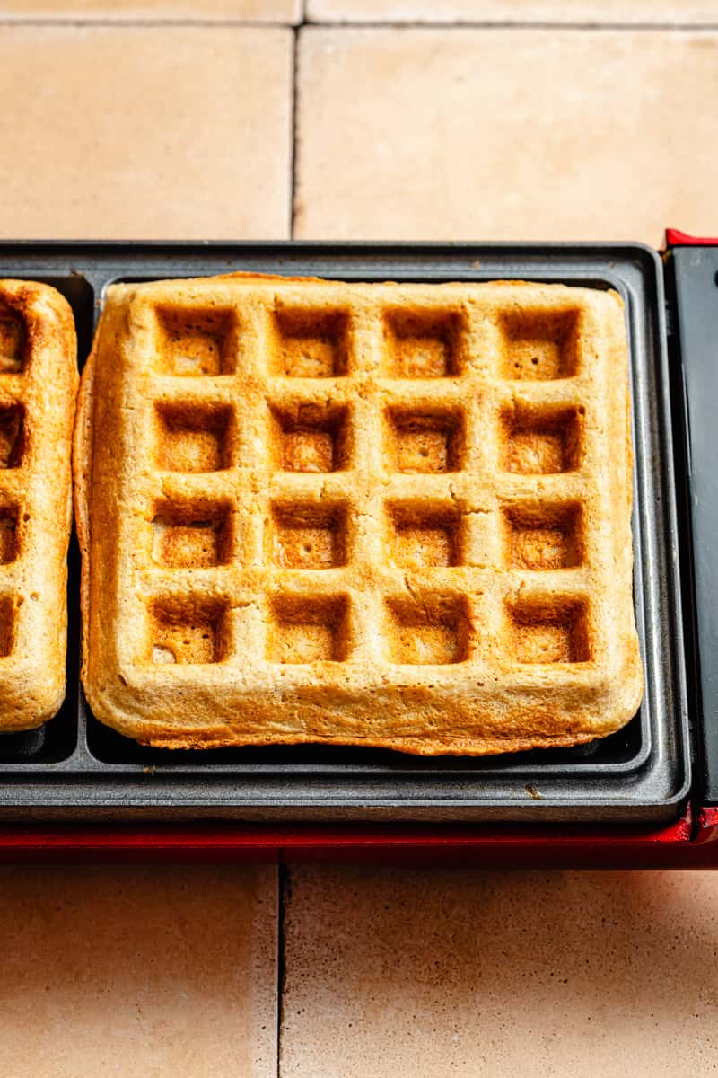 a cooked oatmeal waffle that's perfectly golden brown in a waffle iron.