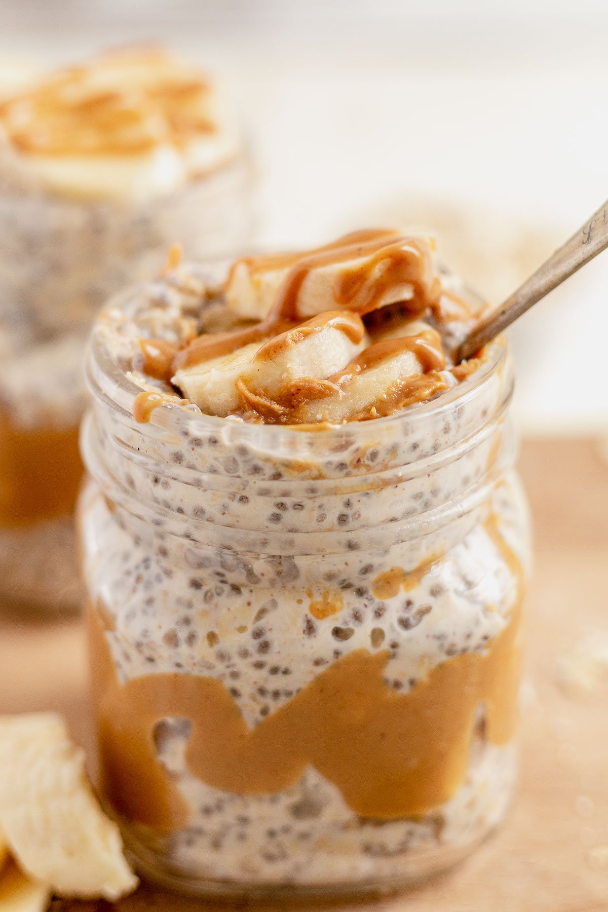 spoon scooping out peanut butter overnight oats from a glass jar