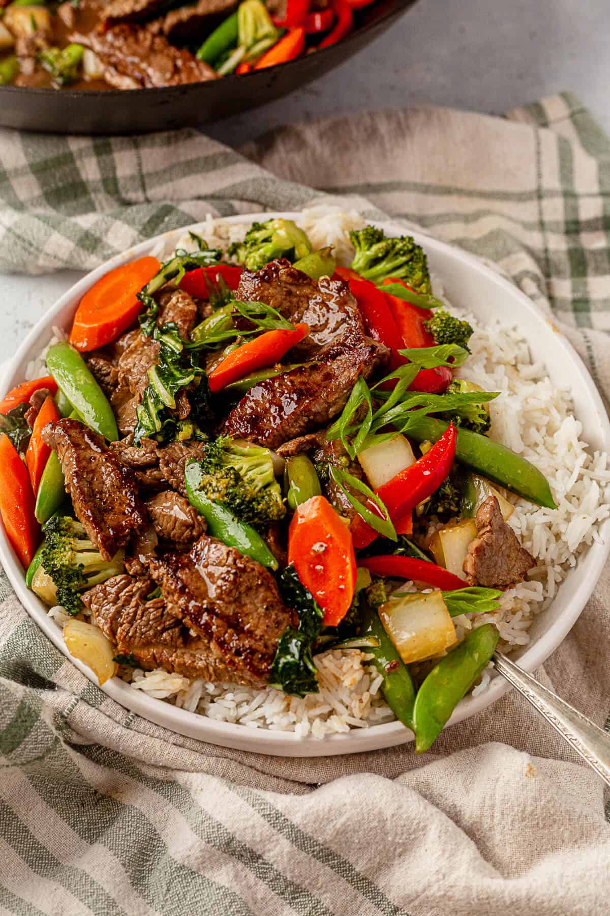 flank steak stir fry with white rice and topped with green onions