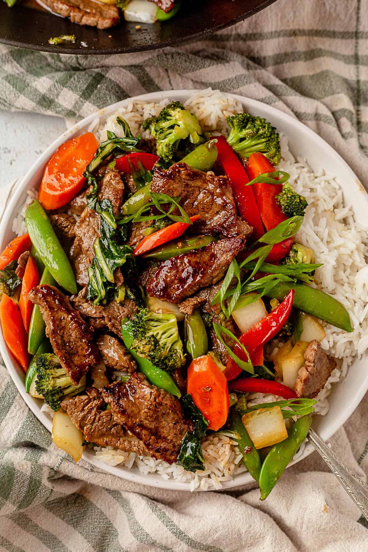 a bowl of flank steak stir fry with white rice