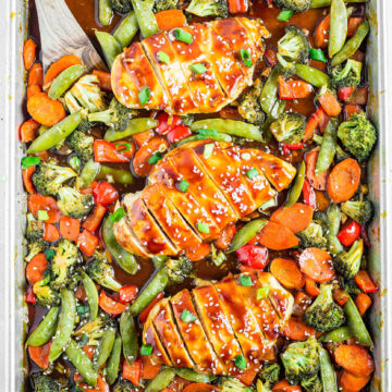 3 pieces of healthy chicken teriyaki on a sheet pan surround by mixed roasted vegetables
