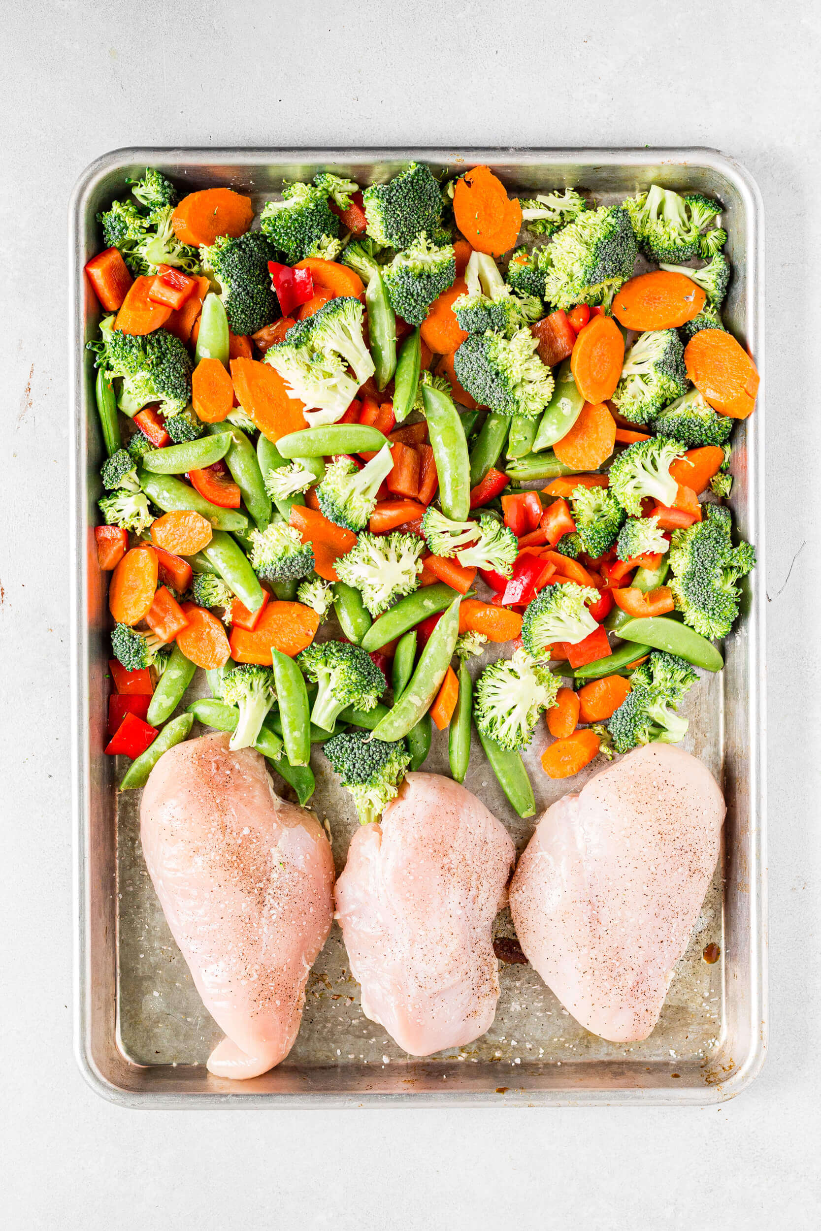 3 pieces of chicken breast and veggies for healthy chicken teriyaki recipe before being baked