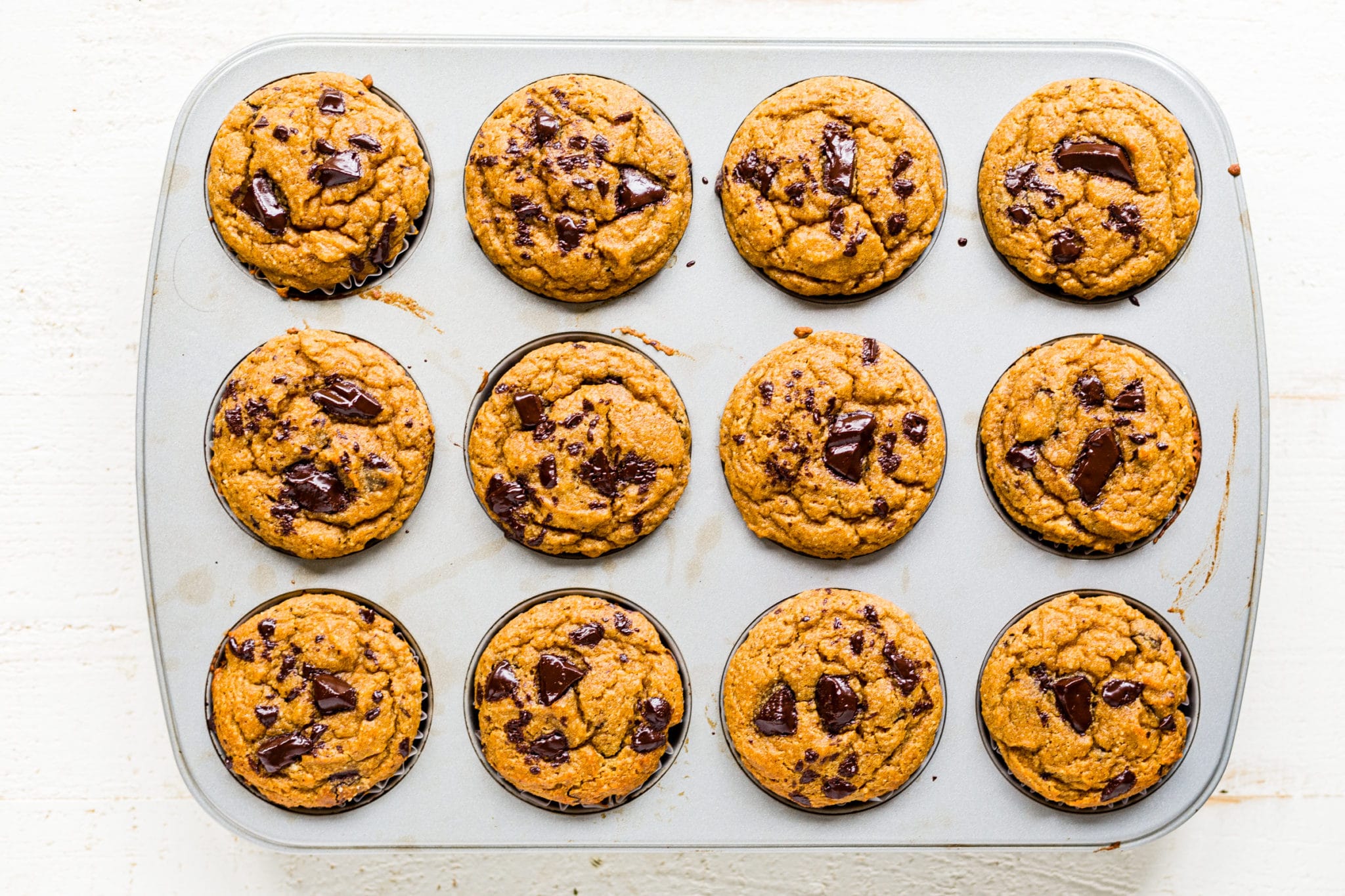 healthy pumpkin muffins cooling in a muffin tin.