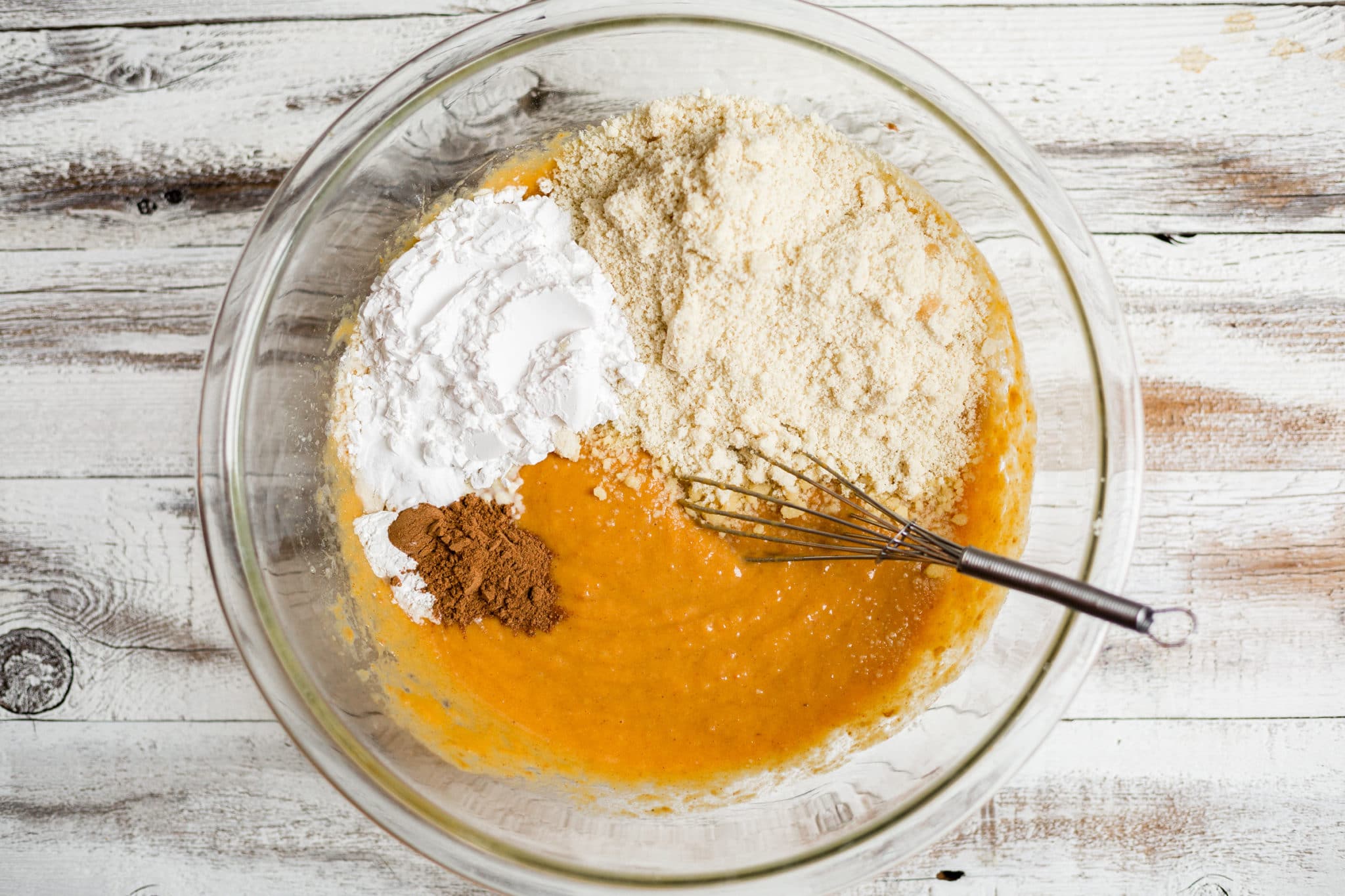 mixing dry ingredients into pumpkin muffin batter.