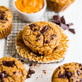 healthy pumpkin muffin unwrapped on a table with chocolate chips