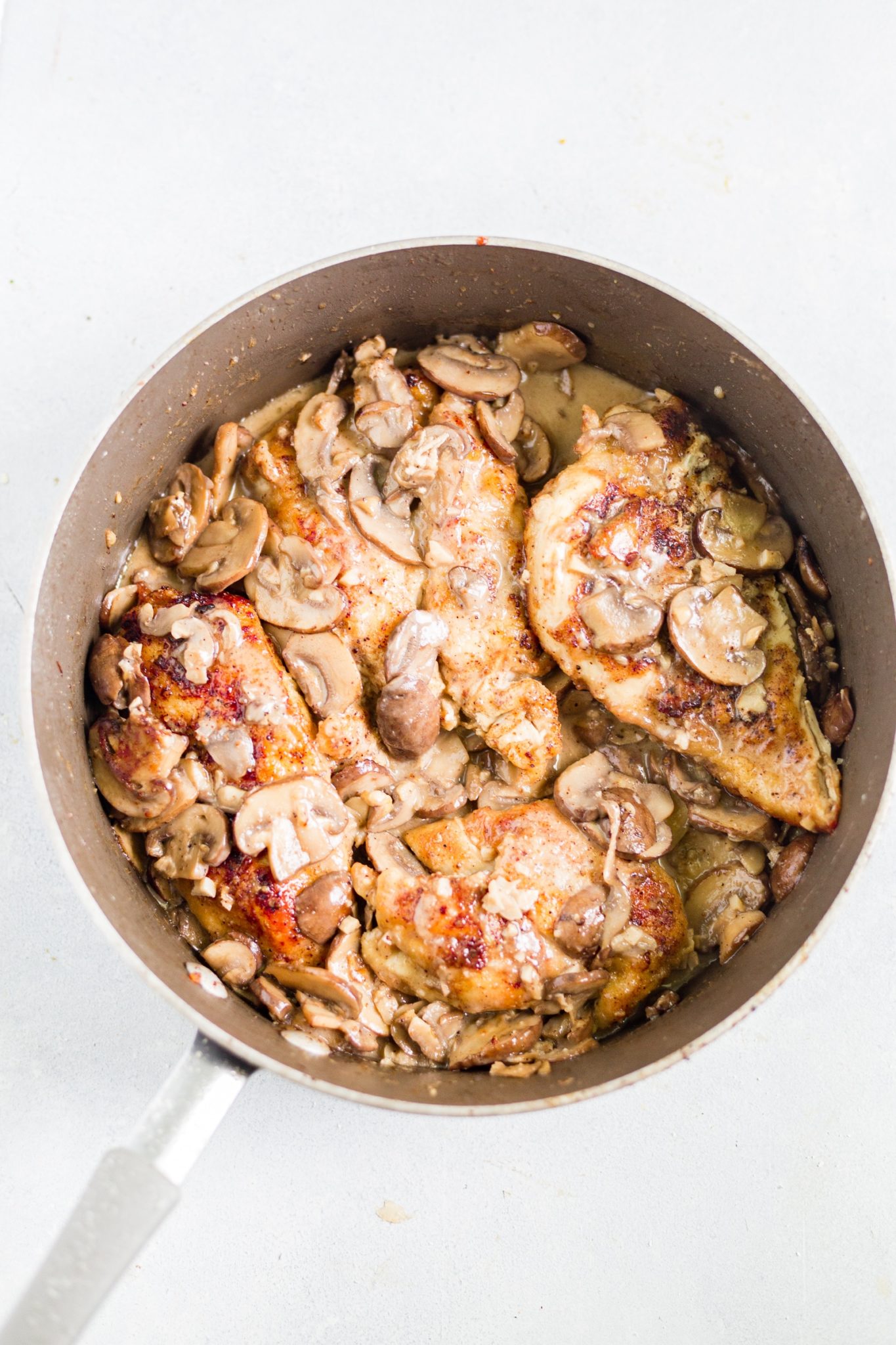 healthy chicken marsala cutlets in a pan with mushroom sauce
