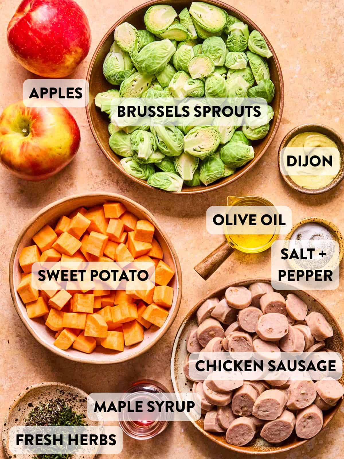ingredients for maple dijon sausage and veggies separated into bowls and sitting on a counter.