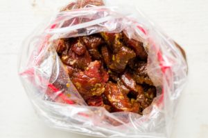 sirloin steak marinading in a freezer bag with soy sauce, garlic and ginger