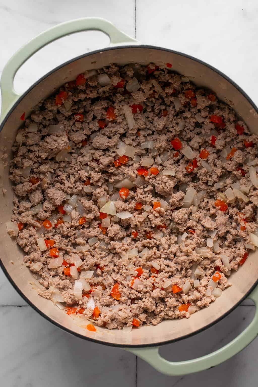 ground turkey turkey, peppers, and onions cooked in a soup pot.