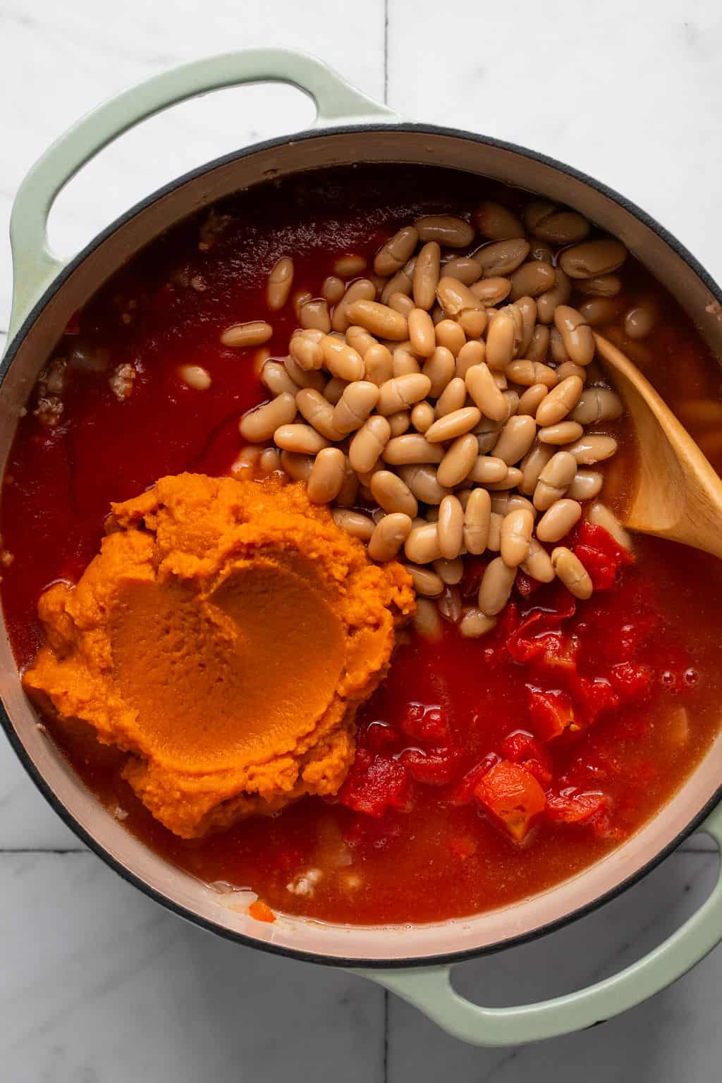 turkey pumpkin chili ingredients in a dutch oven.