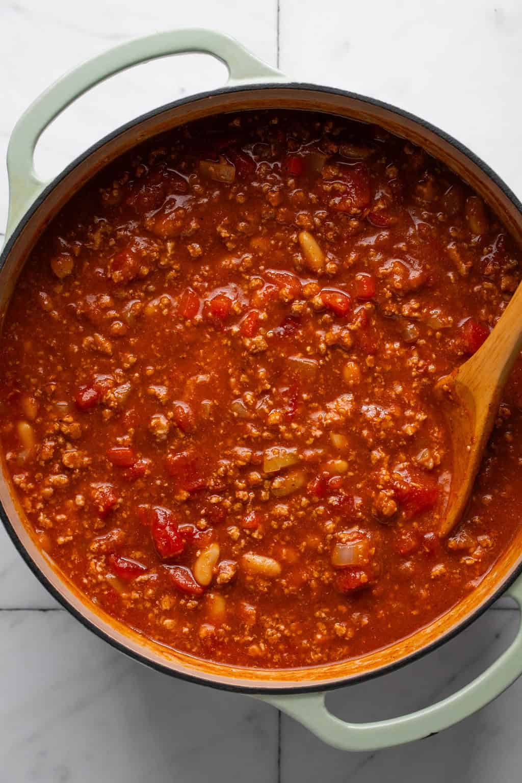 pumpkin and turkey chili cooking in a pot on the stove.