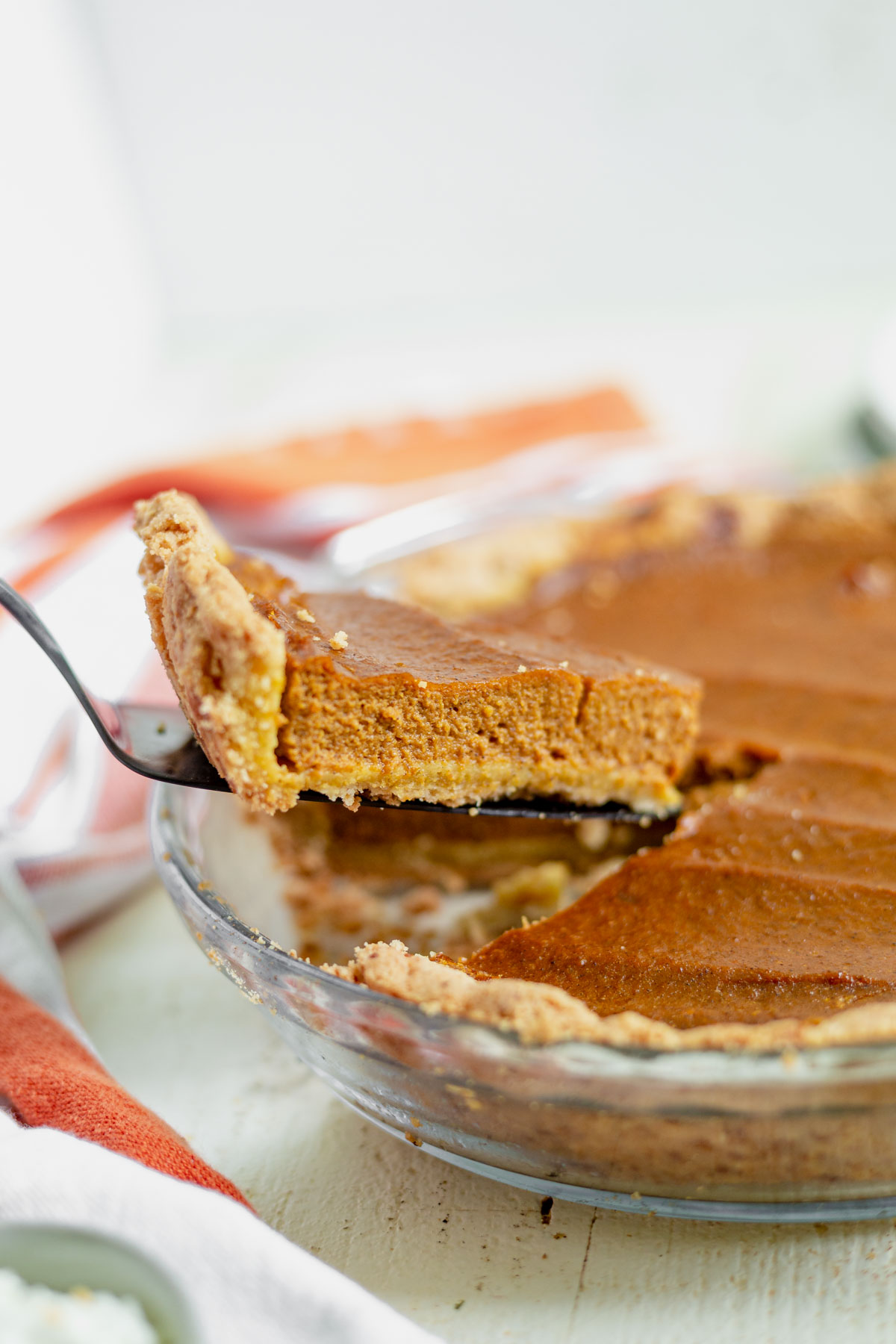 a slice of dairy free pumpkin pie being pulled out of the pie pan