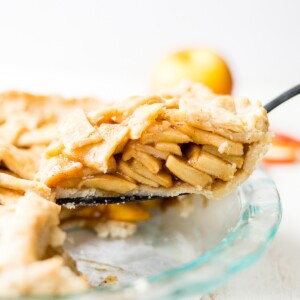 gluten free apple pie slice being pulled out of a glass baking dish