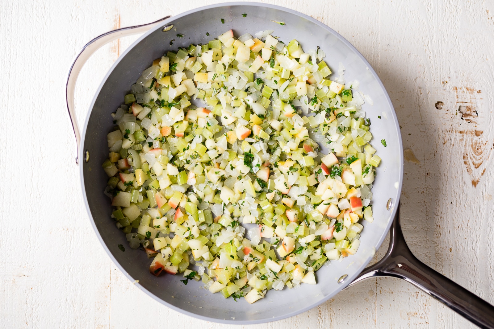 sauteed apples, onion and celery in a pan