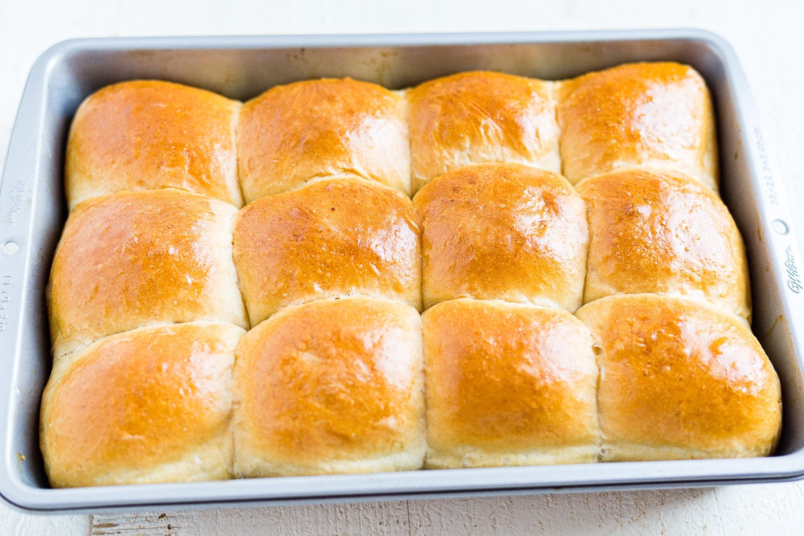 12 baked sourdough rolls in the pan with golden brown tops