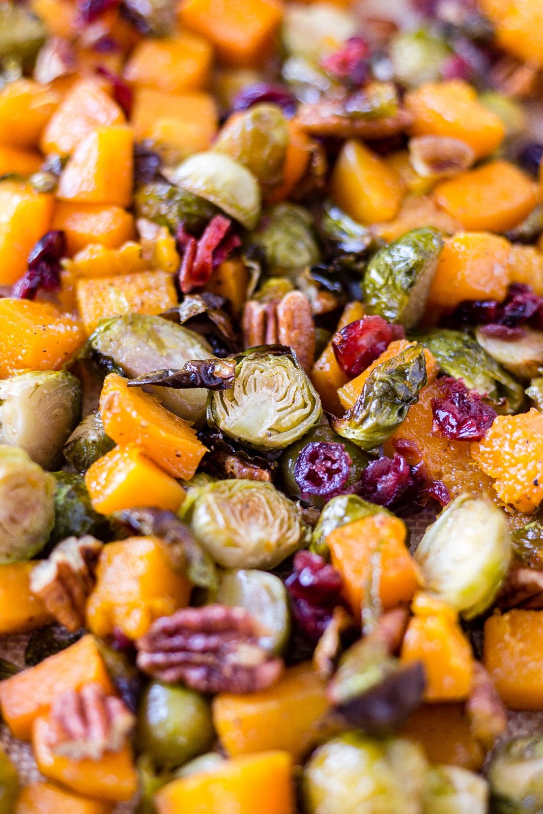 brussel sprouts and butternut squash roasted on a sheet pan with pecans and cranberries