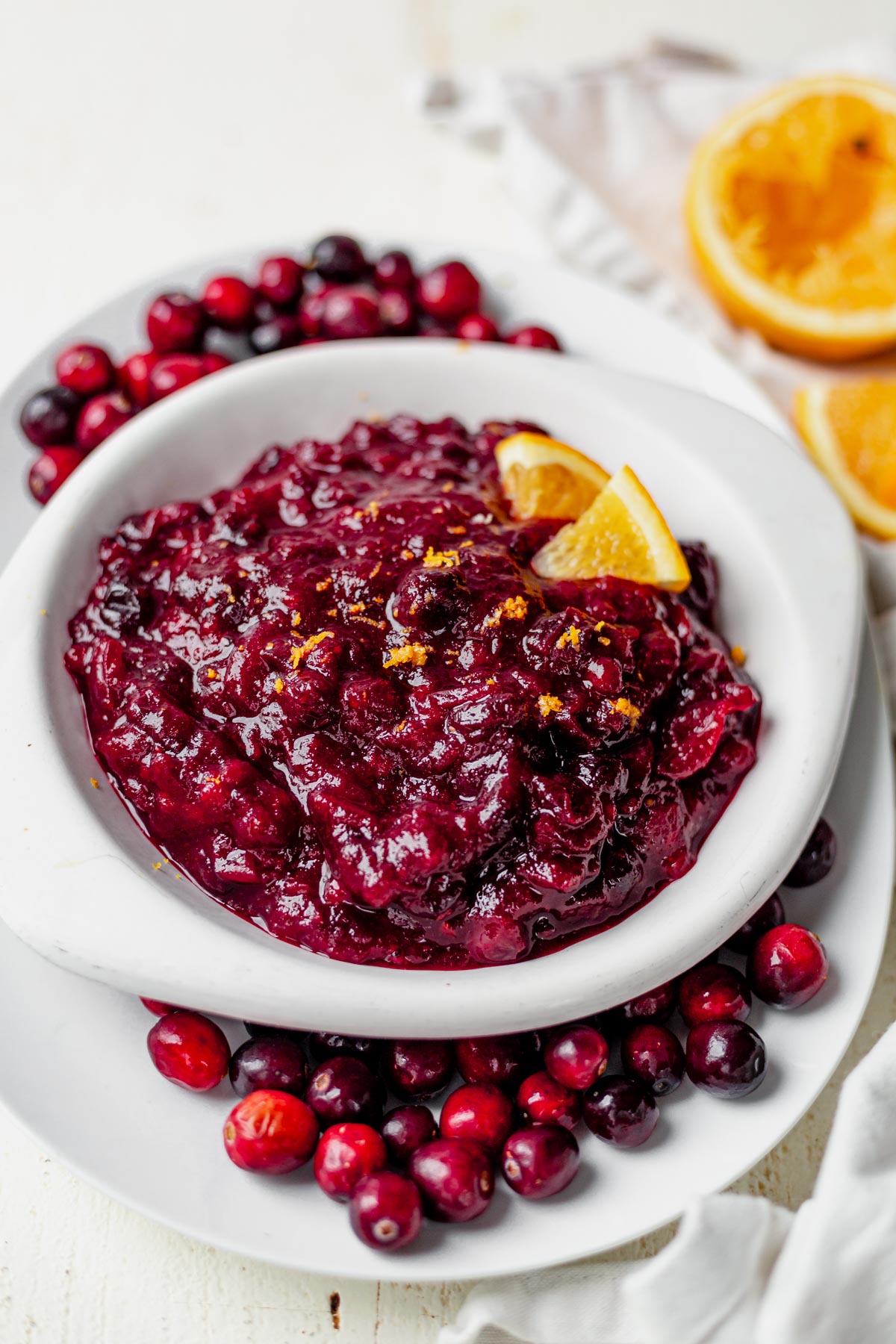 healthy cranberry sauce in a serving dish with fresh orange zest on top