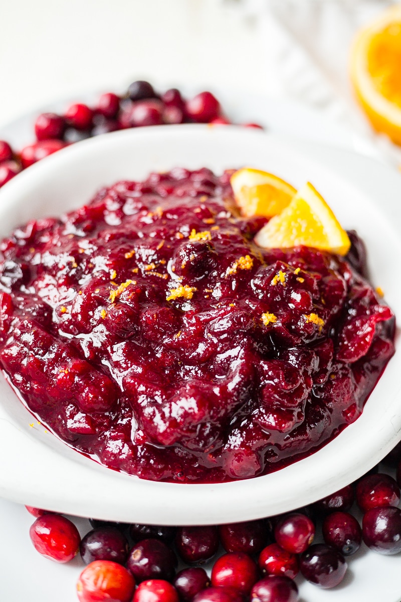 healthy cranberry sauce in a white bowl with orange zest on top
