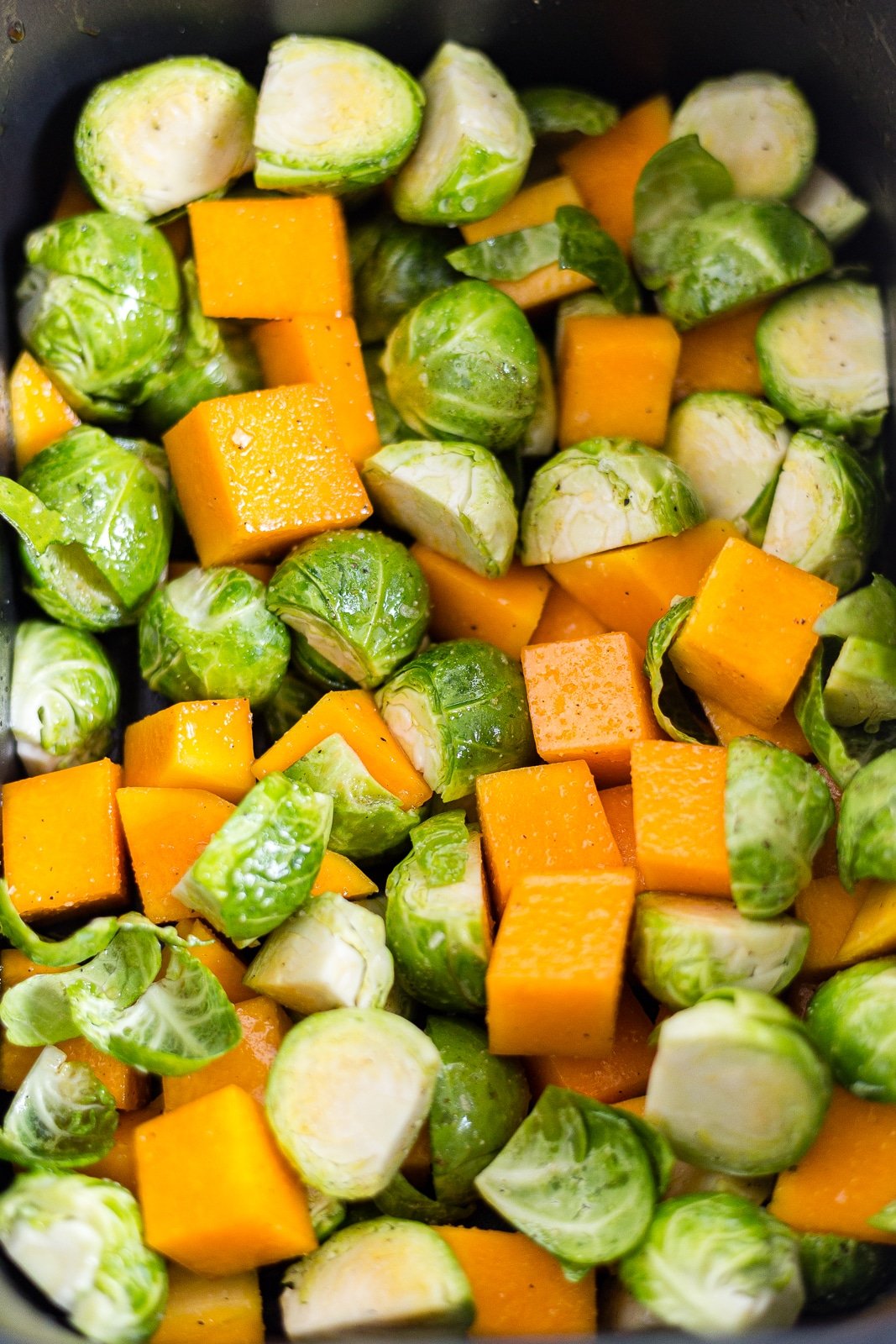 brussel sprouts and butternut squash in an air fryer basket