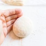 hand rolling sourdough bun dough into a smooth ball before baking