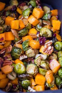 crispy butternut squash and brussel sprouts with cranberries and pecans