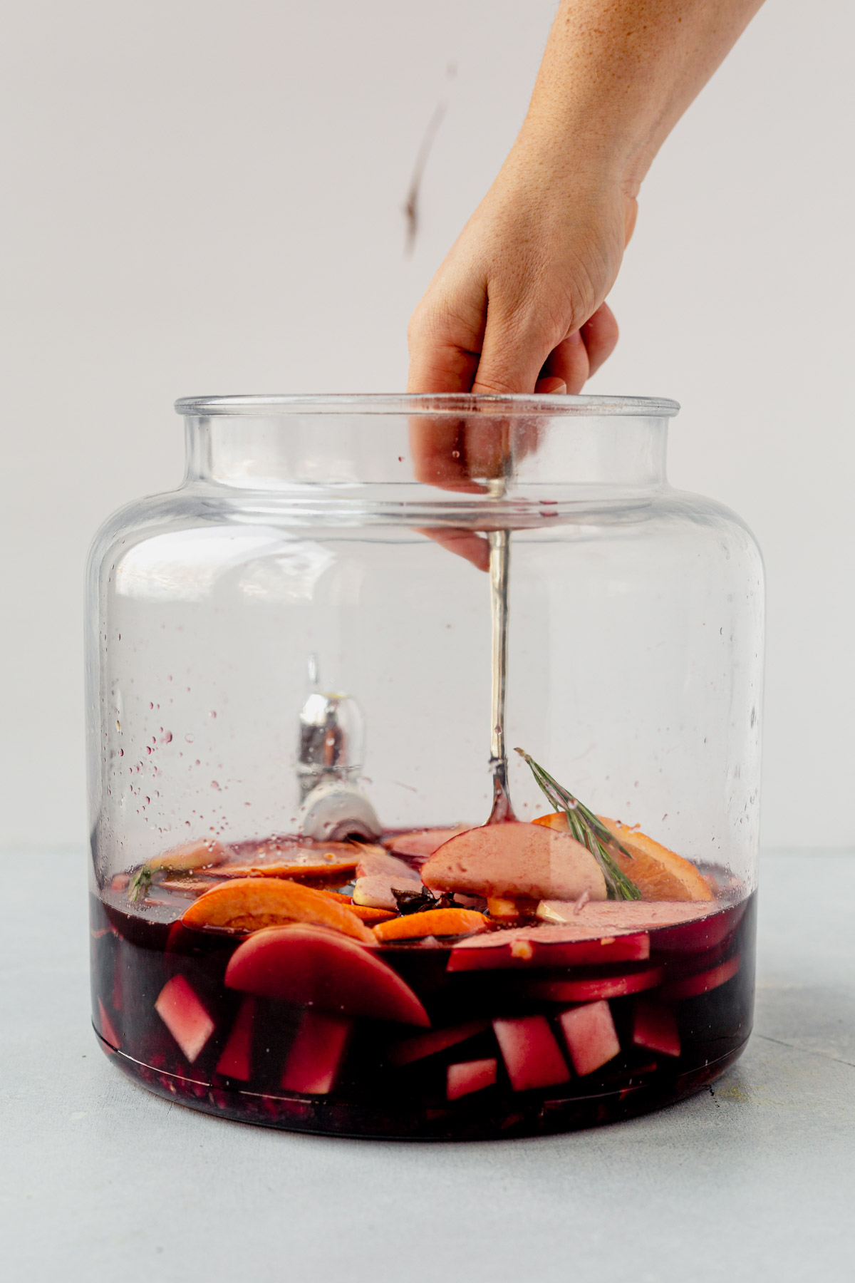 stirring winter sangria in a pitcher