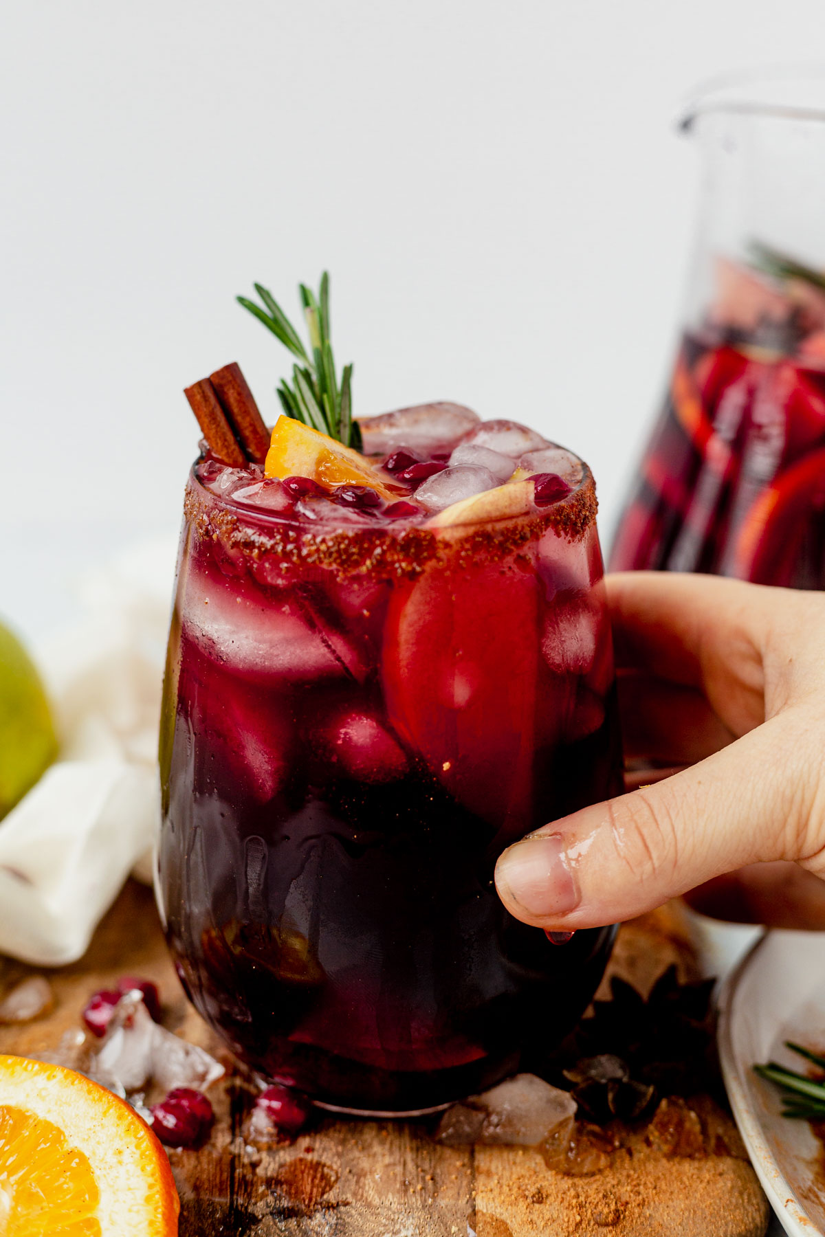 spiced winter sangria in a stemless wine glass with rosemary and cinnamon