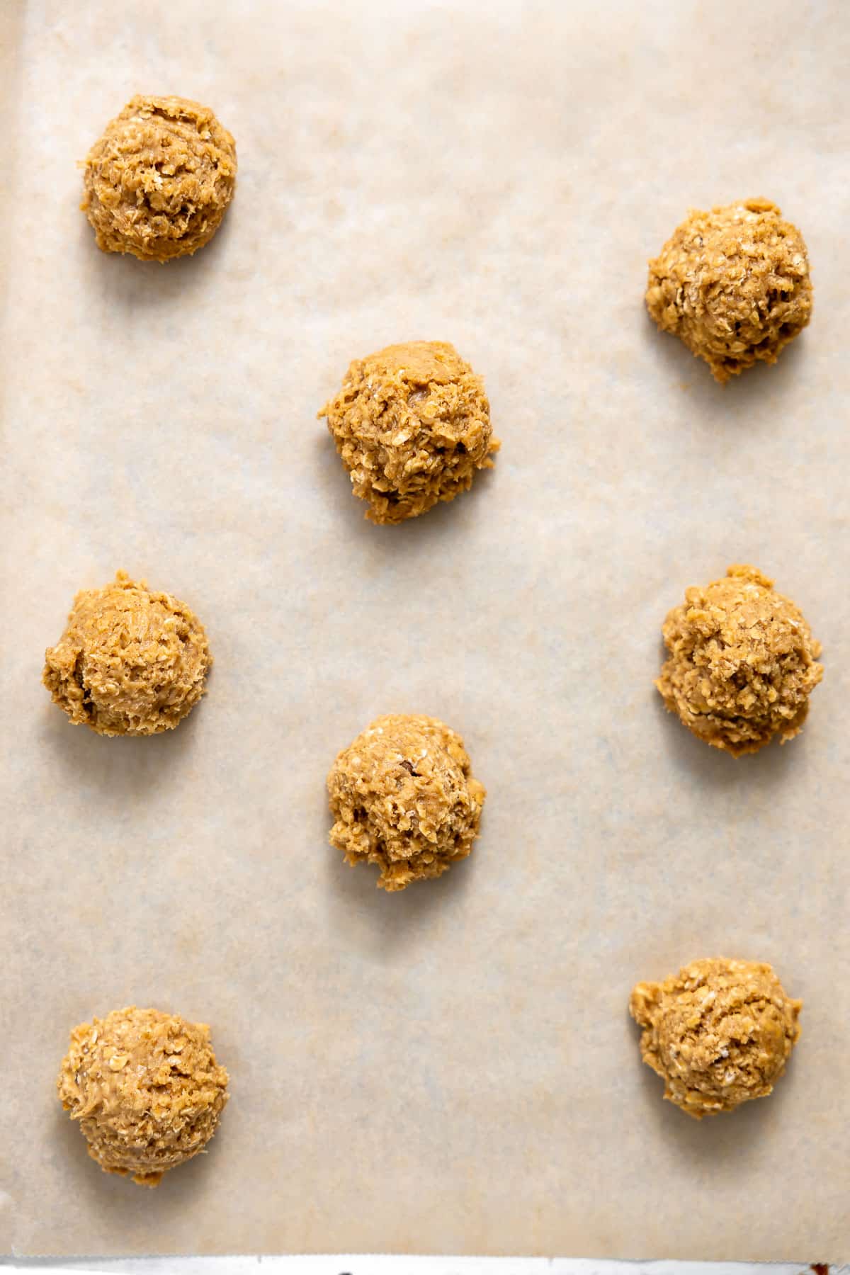 brown butter oatmeal cookie dough balls on a baking sheet.