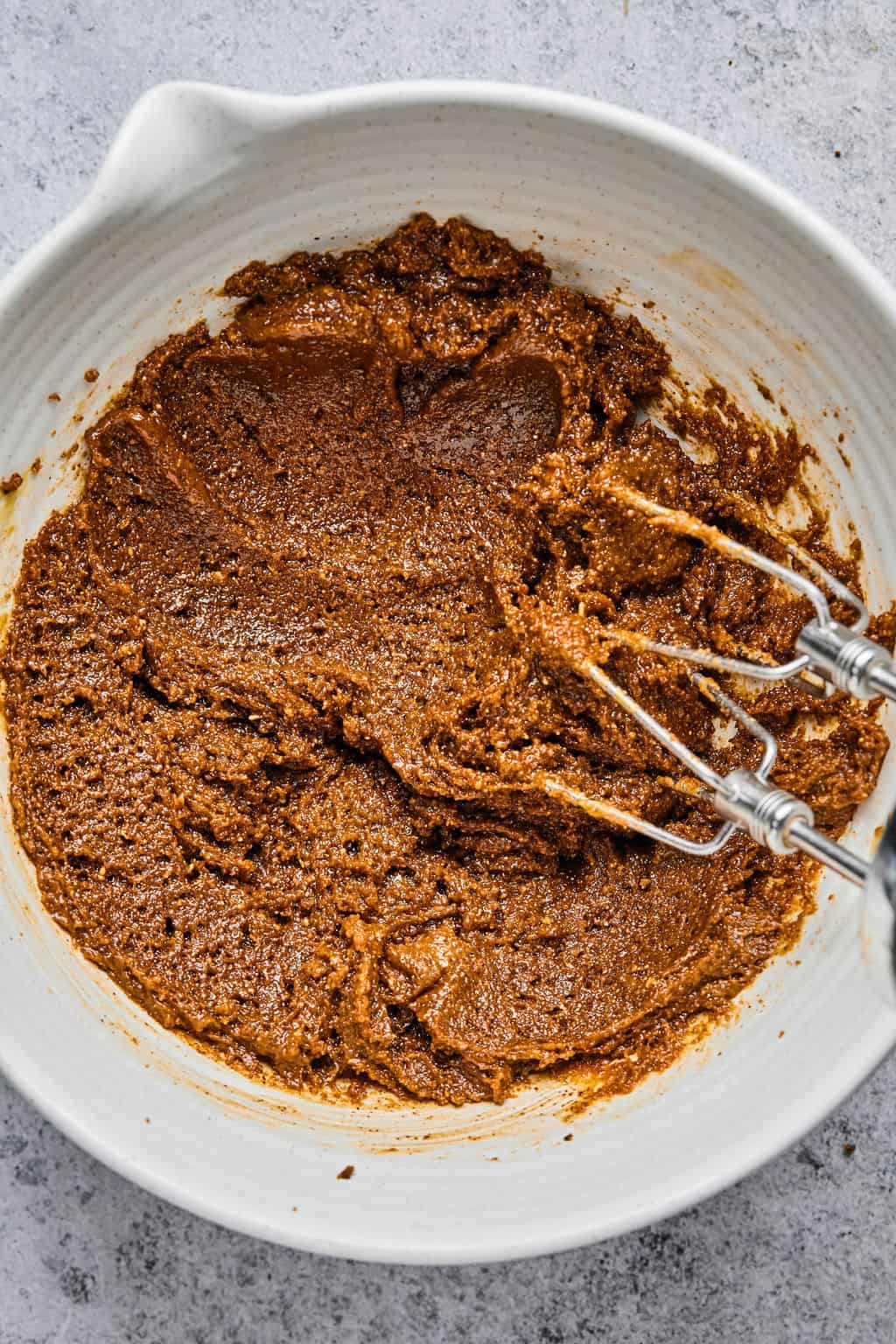 almond butter cookie dough in a bowl with hand mixers.