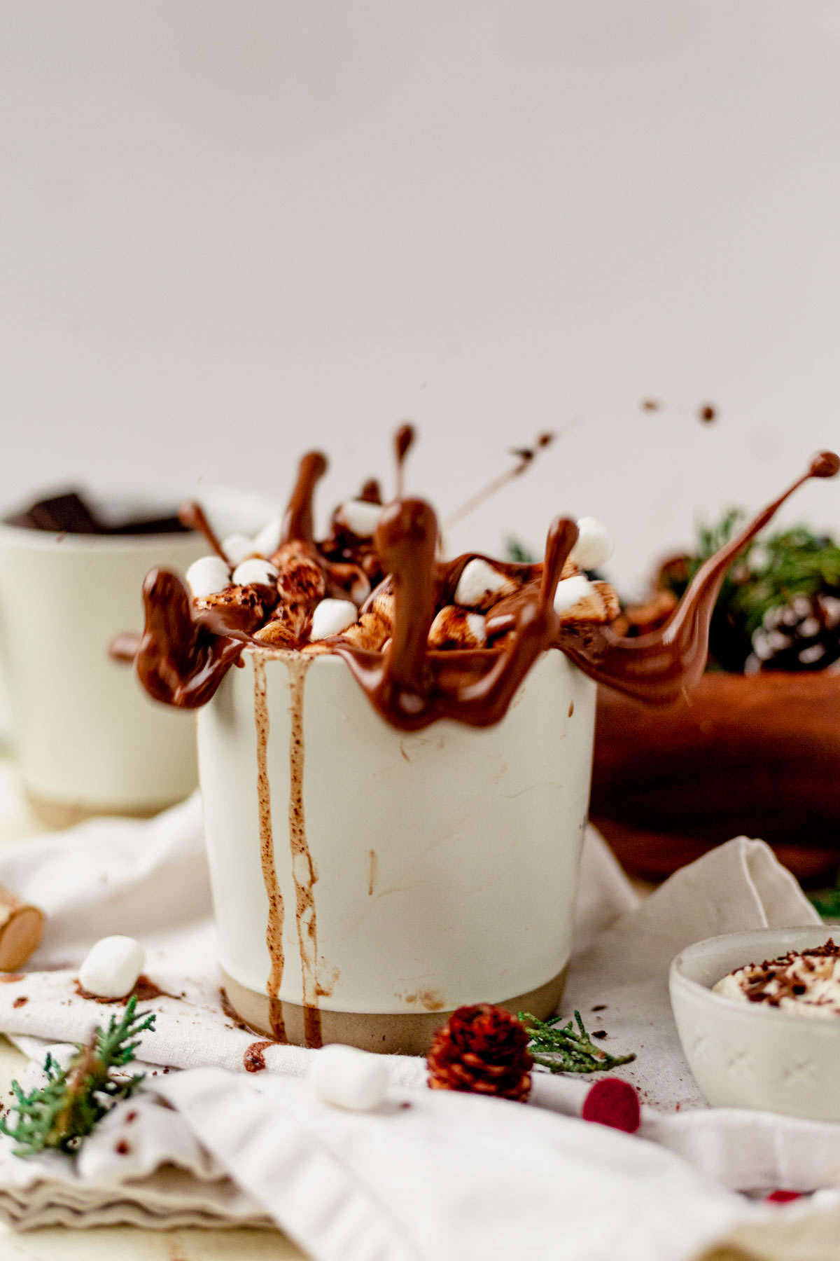 marshmallows splashing into a mug of vegan hot chocolate