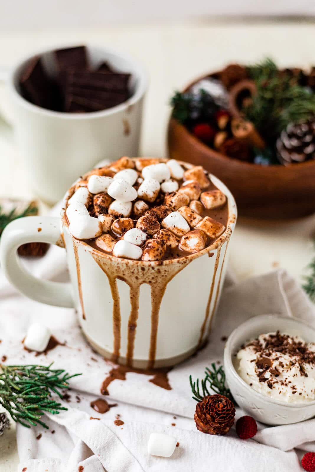 healthy hot chocolate in a white mug with mini marshmallows and hot chocolate dripping over the sides