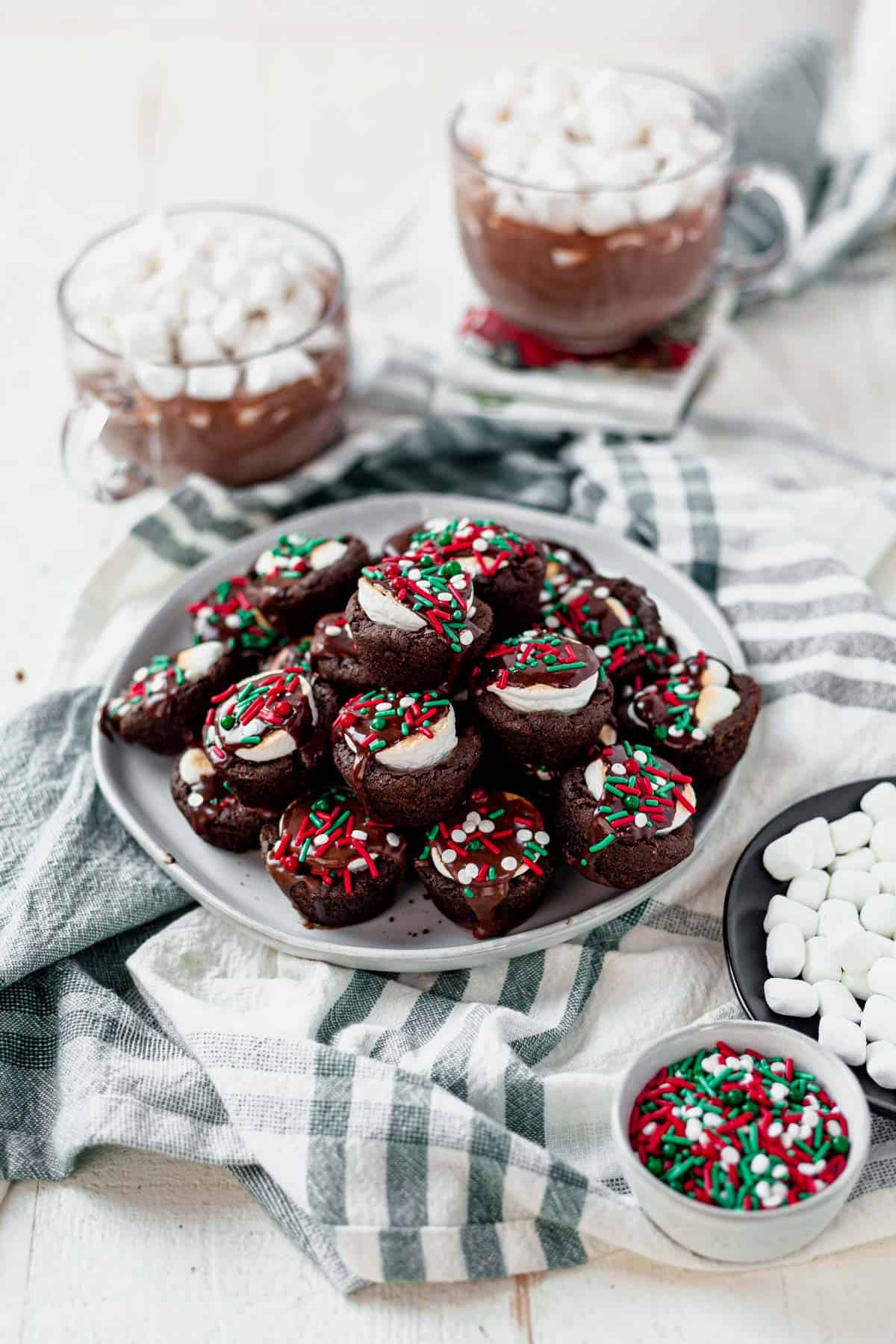 a platter of hot cocoa cookies with two mugs of hot cocoa