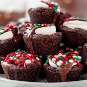 a plate of hot cocoa cookies with melted chocolate and sprinkles