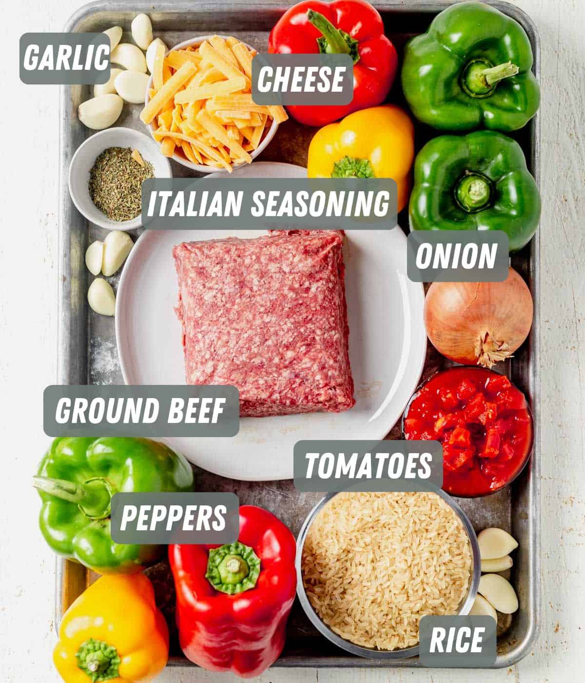 ground beef, bell peppers, uncooked rice, garlic, onion and cheese on a tray
