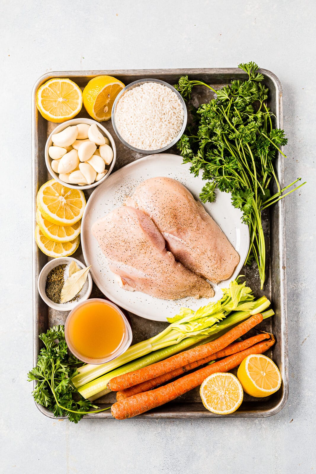 ingredients for greek lemon chicken soup laid out on a sheet pan