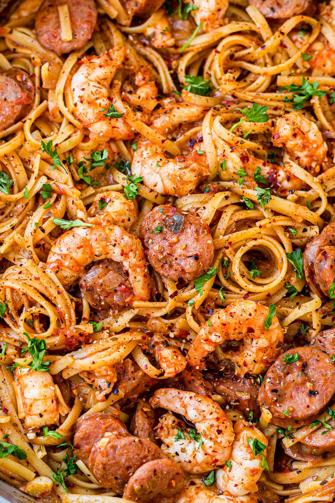 close up of cajun shrimp and sausage pasta with a creamy cajun sauce and fresh parsley