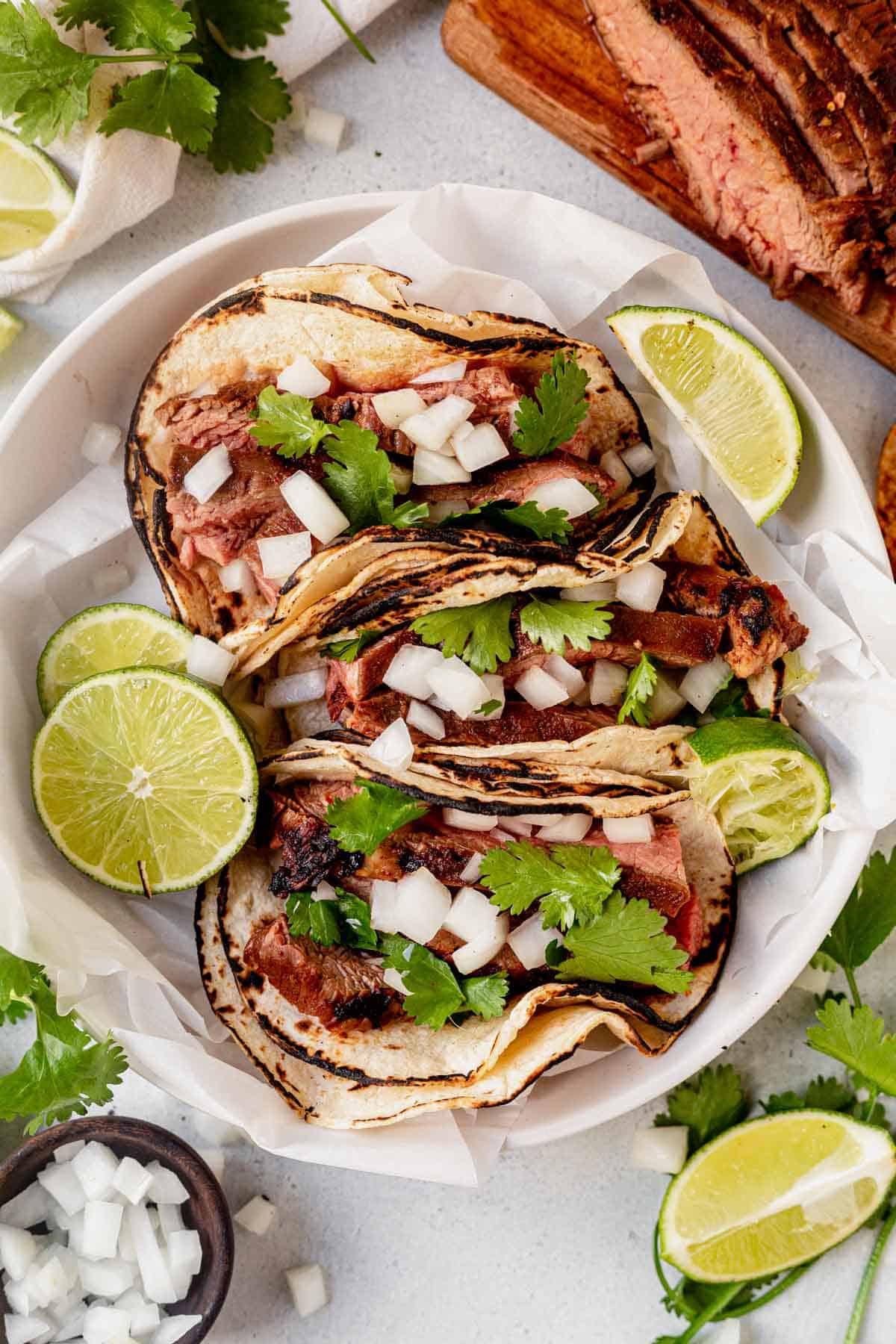 three carne asada tacos on a serving plate
