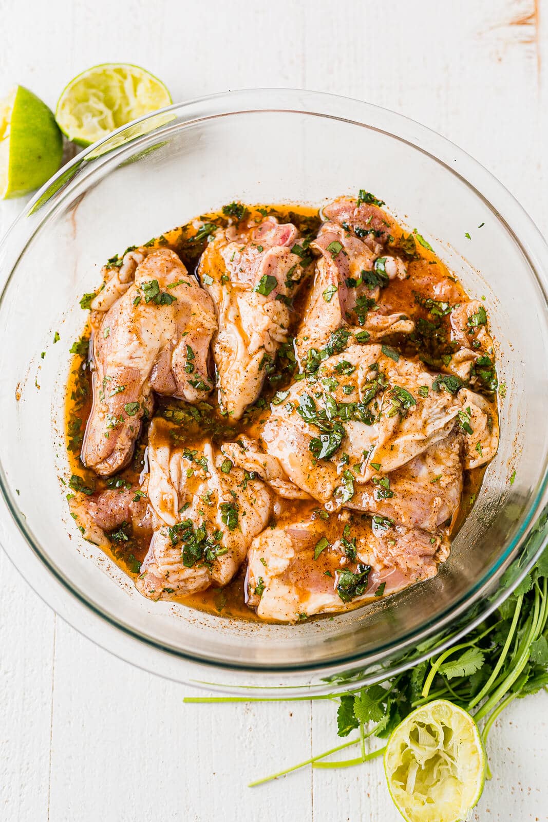 cilantro lime chicken marinade with chicken thighs in a glass bowl