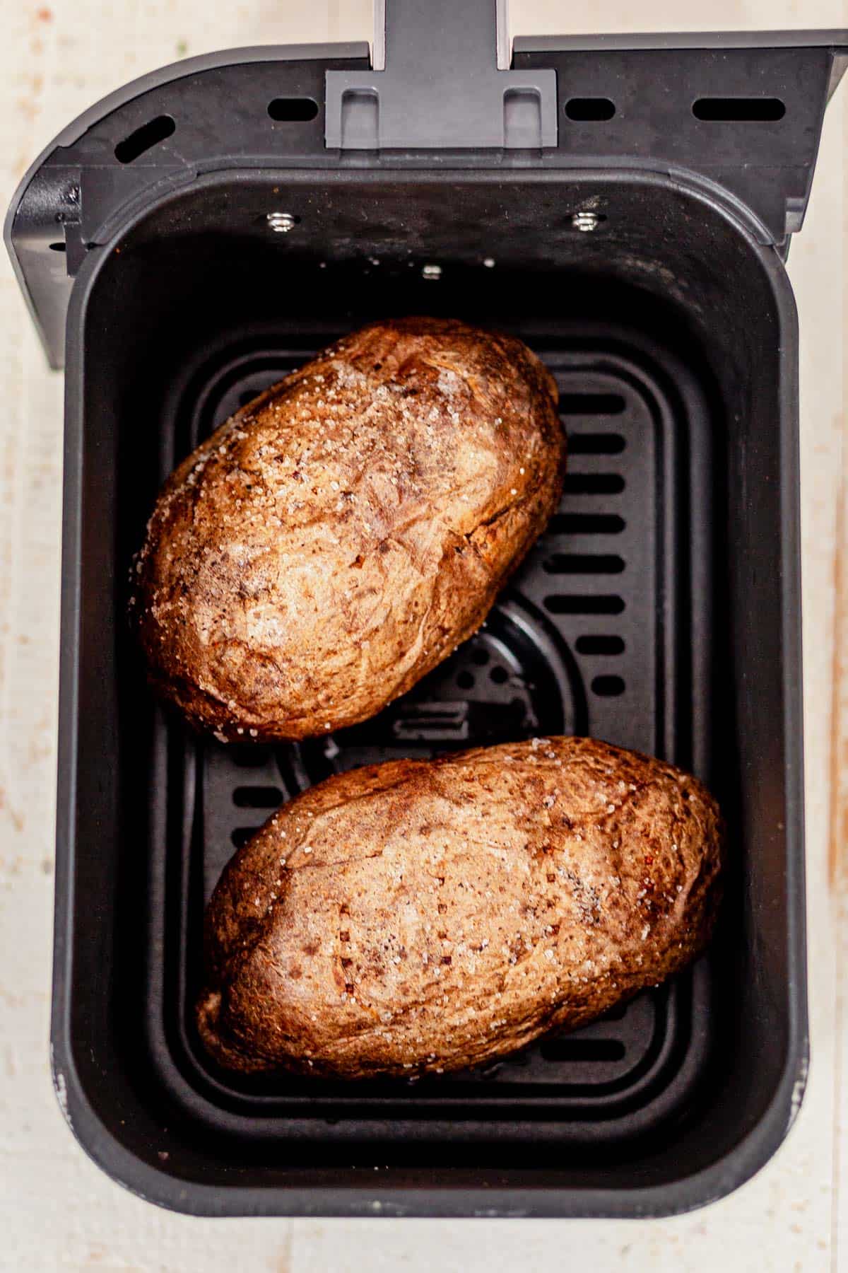 crispy baked potatoes in the air fryer basket.