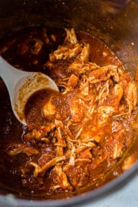 shredded chicken tinga in the instant pot with a gray spatula