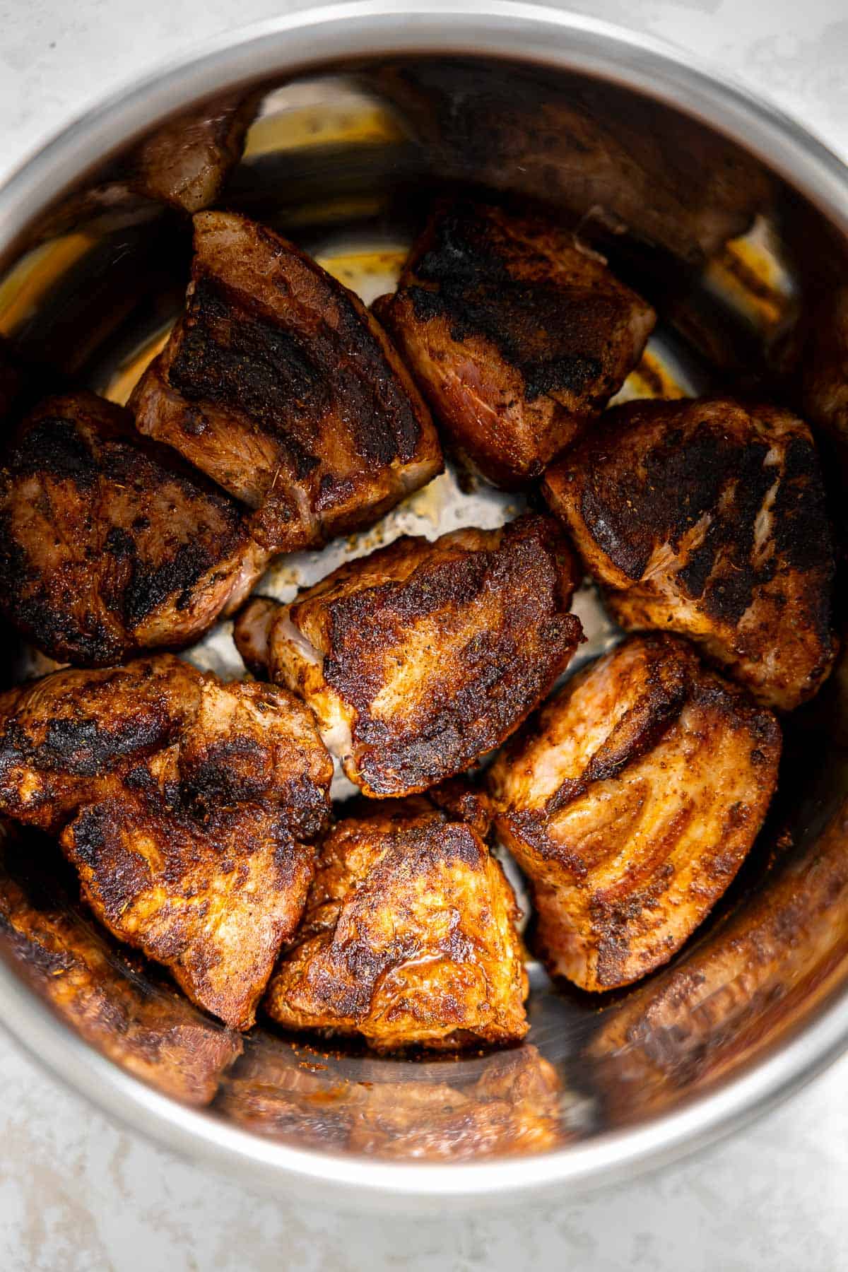 pork shoulder seared to golden brown in an instant pot.