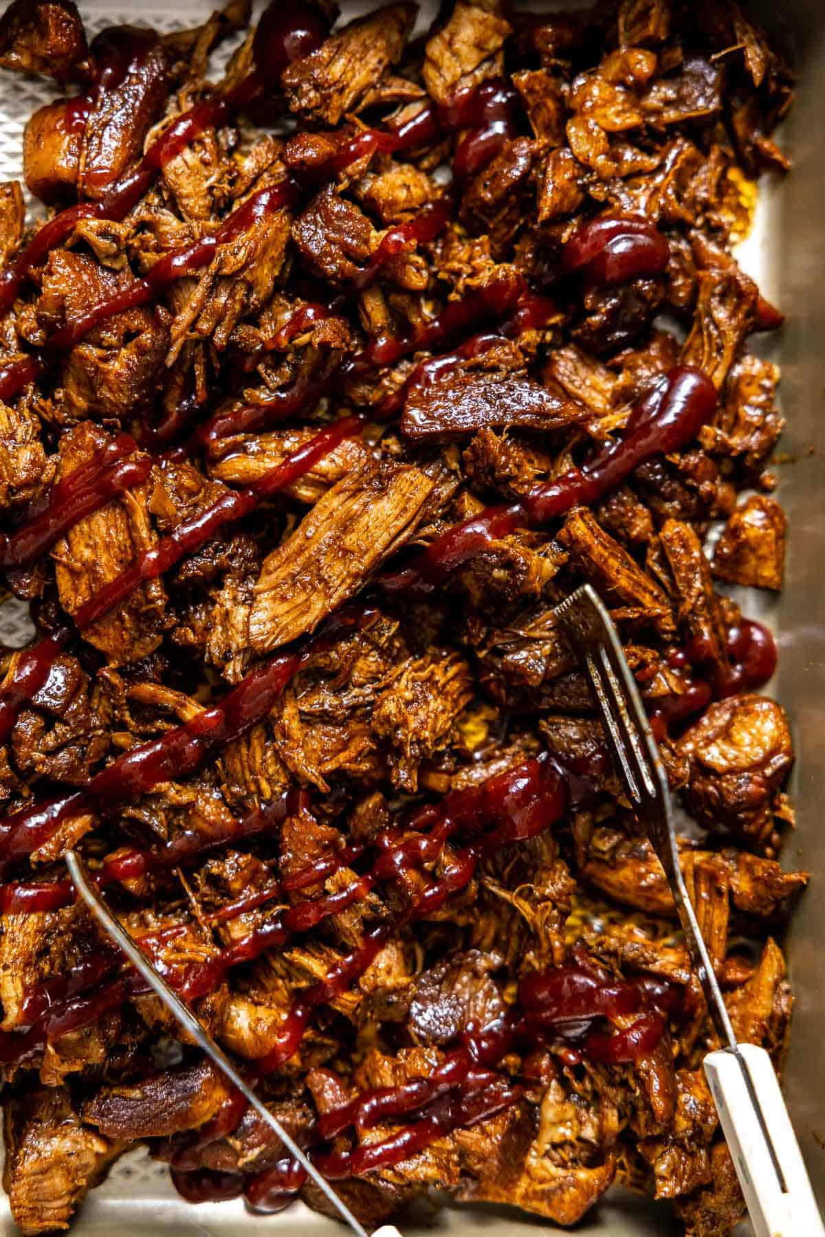 instant pot pulled pork on a sheet pan covered in bbq suace.