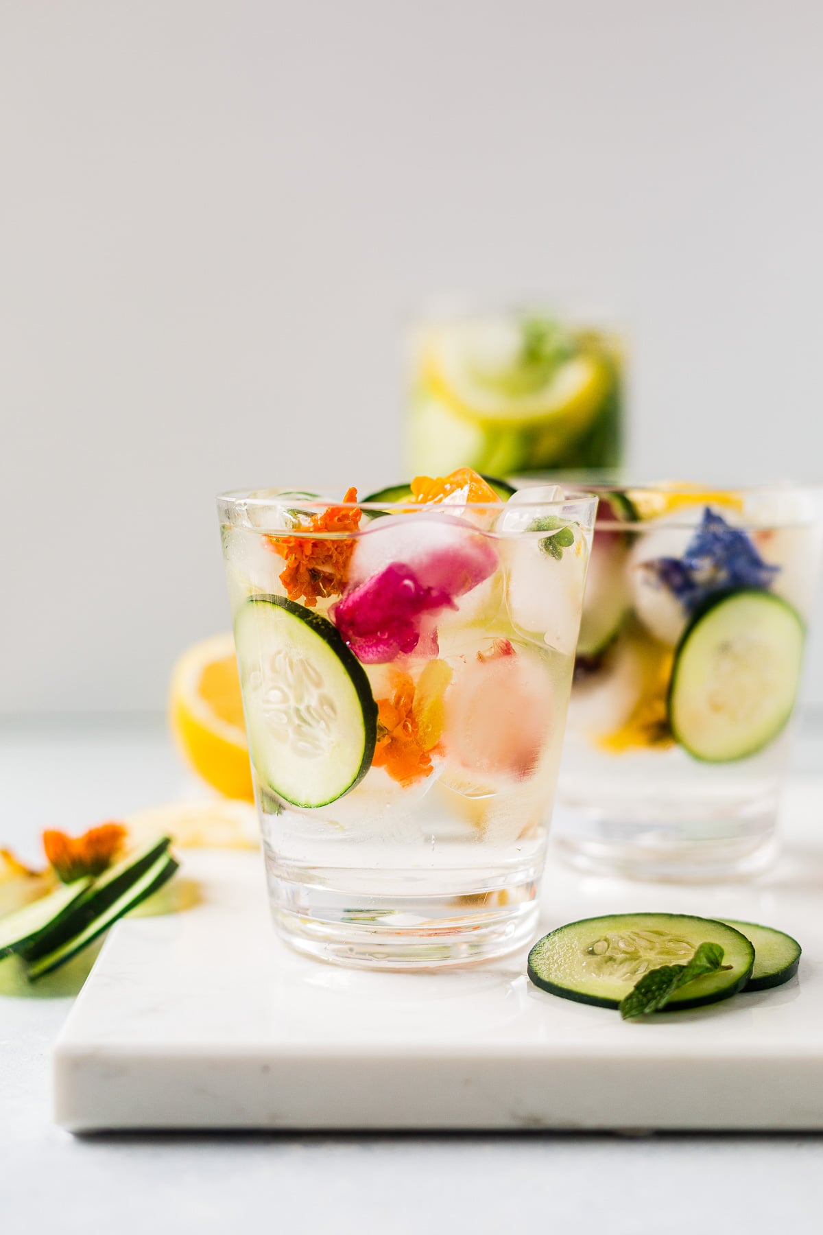 cucumber and lemon water in a cup served with edible flower ice cubes