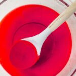 red jello dissolved in a bowl with cold water and vodka