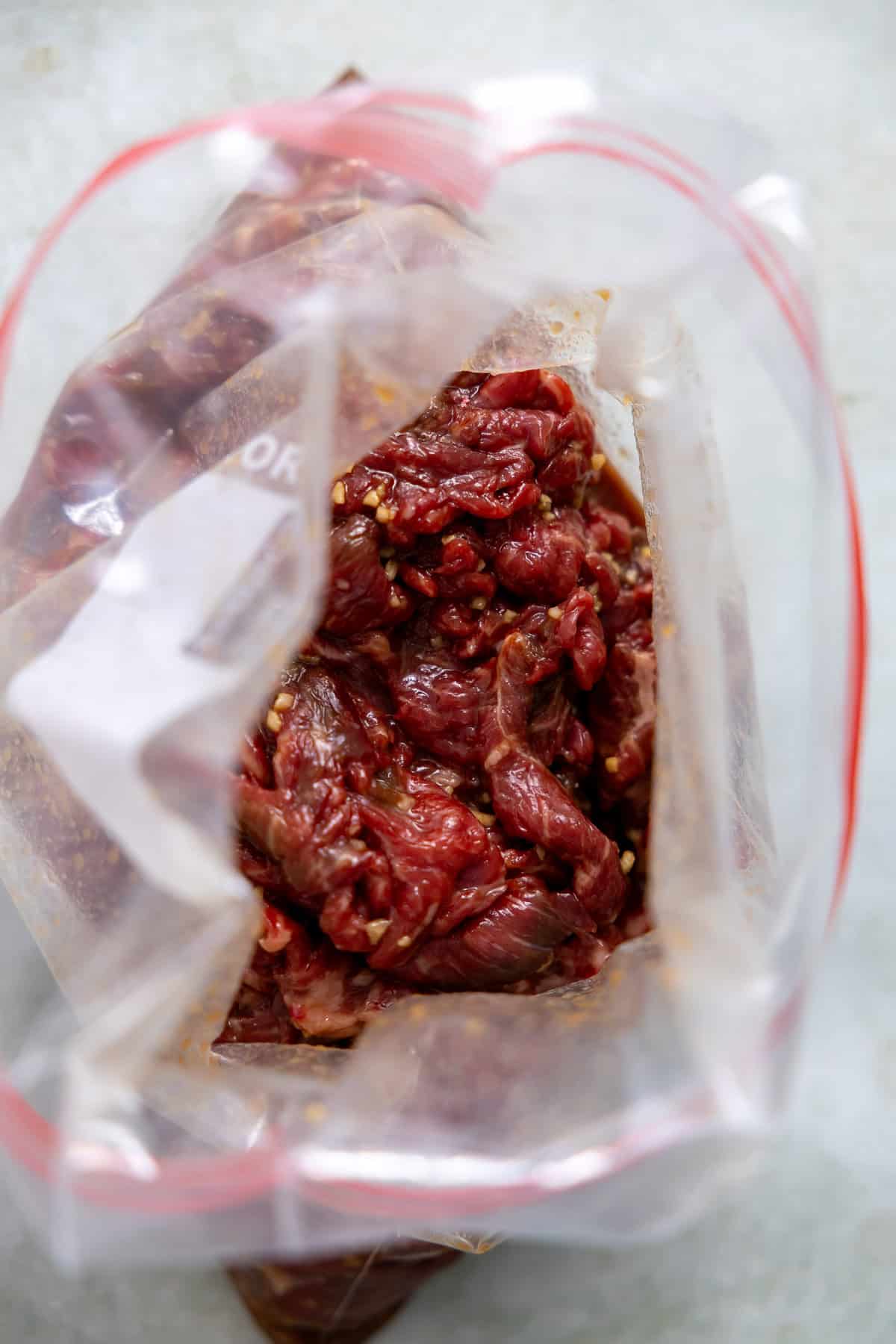 sirloin steak marinading in a freezer bag.