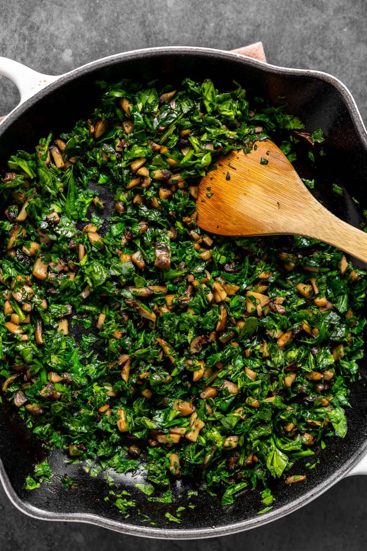 satueed spinach and mushroom in a skillet.